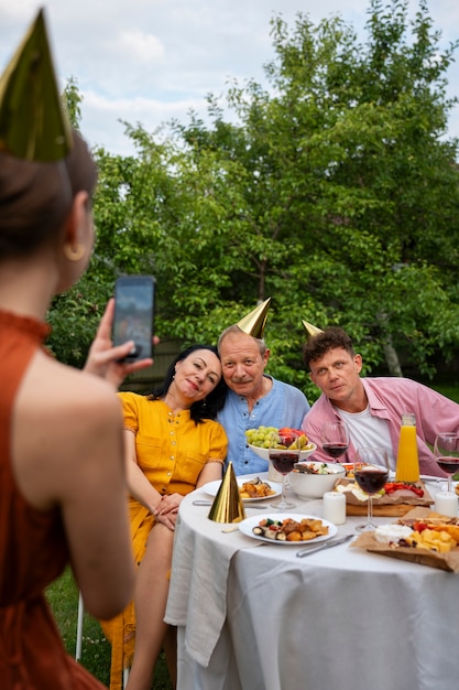 Pessoas celebrando uma festa de aniversário no jardim ao ar livre