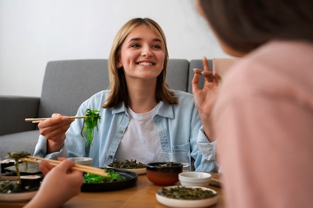 Foto grátis pessoas comendo algas marinhas em casa