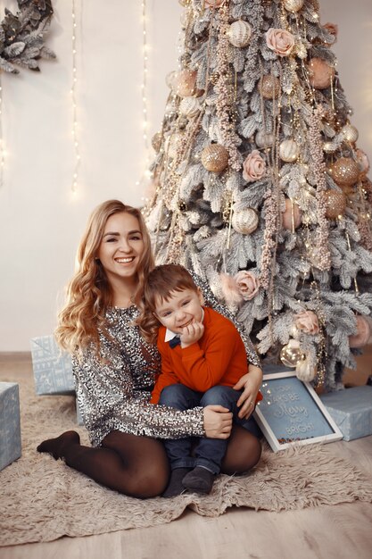 Pessoas consertando para o Natal. Mãe brincando com seu filho.