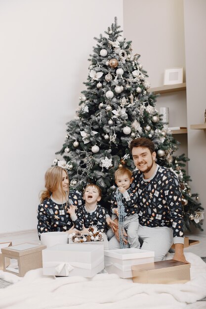 Pessoas consertando para o Natal. Pessoas brincando com uma criança. Família está descansando em uma sala festiva.