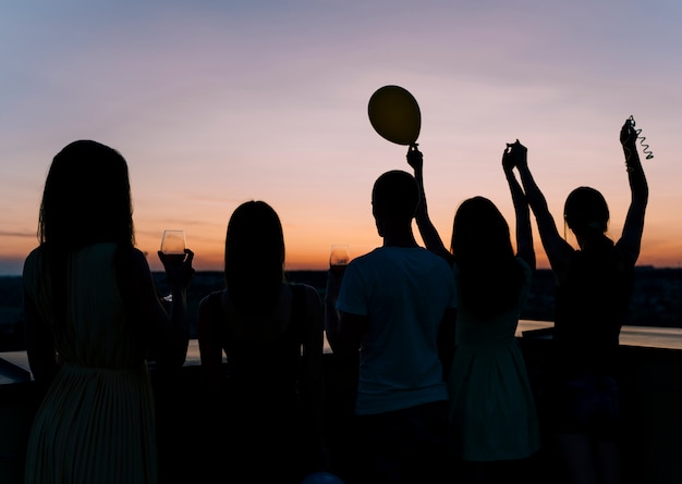 Pessoas dançando na festa no terraço no amanhecer