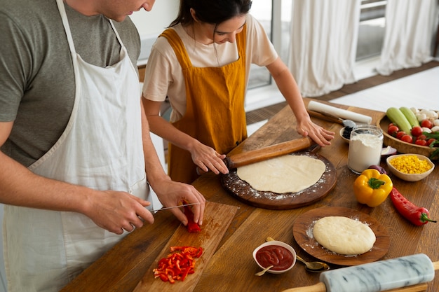 Foto grátis pessoas de alto ângulo cozinhando pizza juntos
