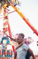 Foto grátis pessoas de baixo ângulo se divertindo no parque de diversões