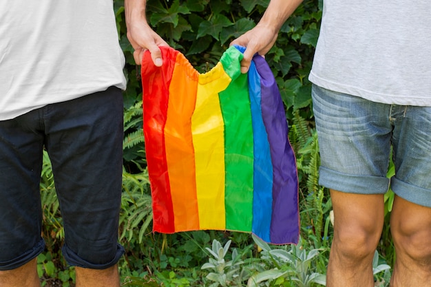 Pessoas de close-up, segurando a bandeira do orgulho gay