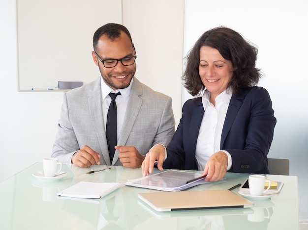 Pessoas de negócios alegres, assinando contrato