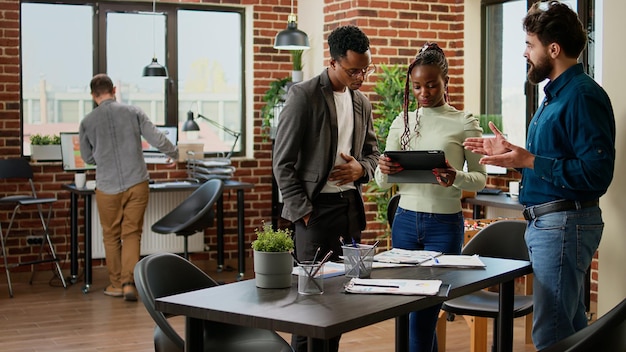 Pessoas de negócios trabalhando em projeto de pesquisa com dados de gráficos em papéis e tablet digital, fazendo colaboração de trabalho em equipe para planejar o relatório. Colegas analisando informações da empresa.