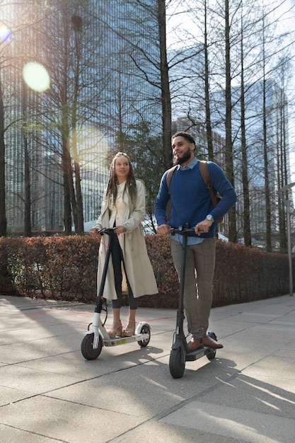 Pessoas de tiro completo com scooters elétricos no parque