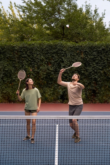 Pessoas de tiro completo jogando badminton