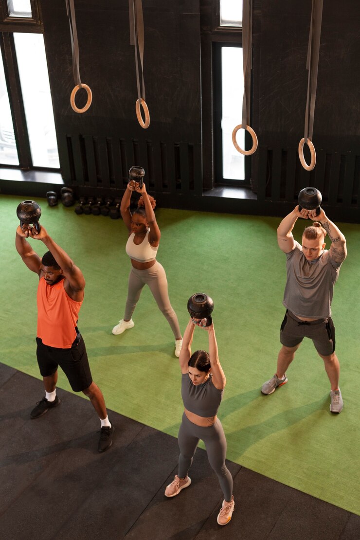 Foto grátis pessoas de tiro completo treinando juntos na academia