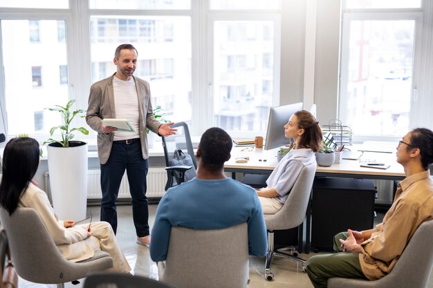 Pessoas de tiro médio aprendendo no trabalho