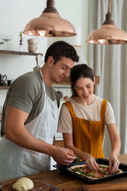 Foto grátis pessoas de tiro médio cozinhando pizza juntas