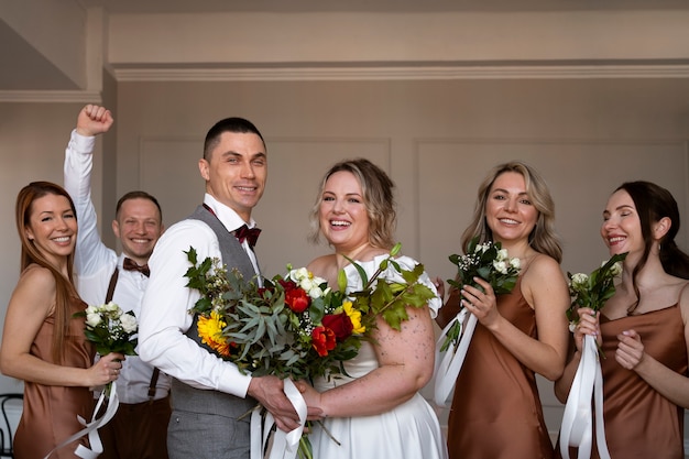 Foto grátis pessoas de tiro médio posando no casamento