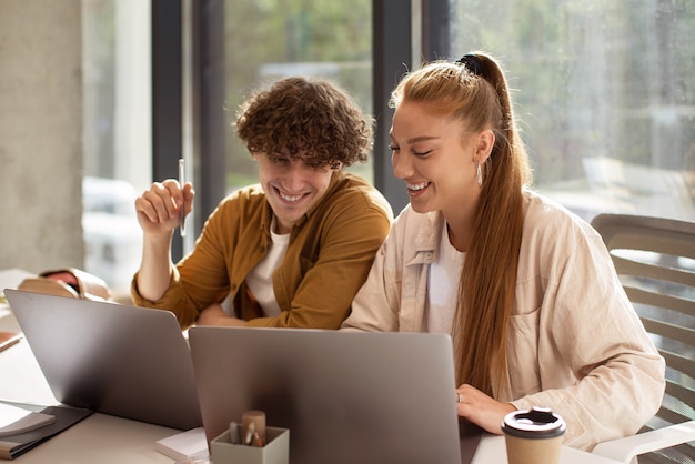 Foto grátis pessoas de tiro médio trabalhando em laptops