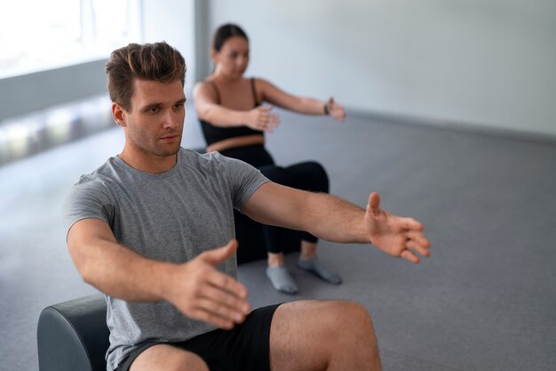 Pessoas de vista lateral fazendo pilates