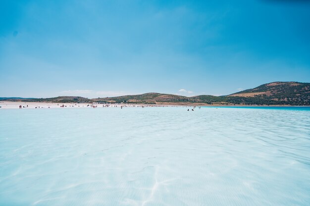 Pessoas descansando na praia aproveitam as férias de verão