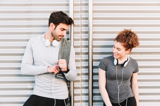 Pessoas desportivas que se comunicam perto da parede