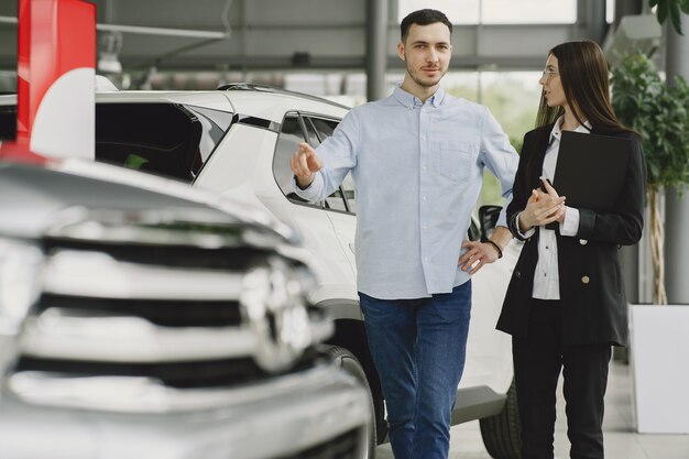 Pessoas elegantes e elegantes num salão de automóveis.