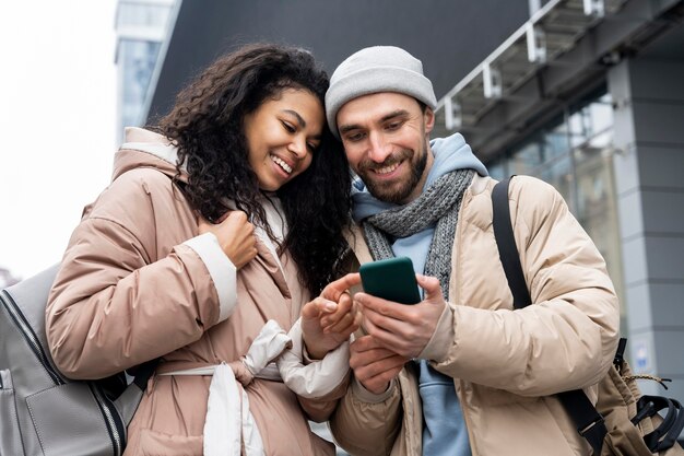 Pessoas em filmagem média olhando para o telefone