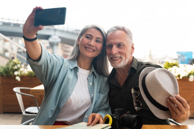 Foto grátis pessoas em filmagem média tirando selfie