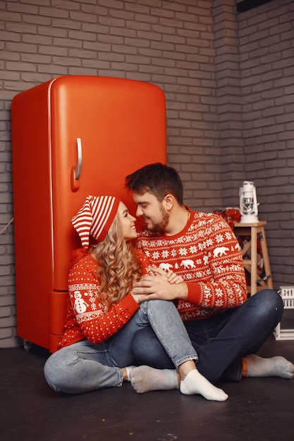 Pessoas em uma decoração de natal. homem e mulher com uma camisola vermelha.