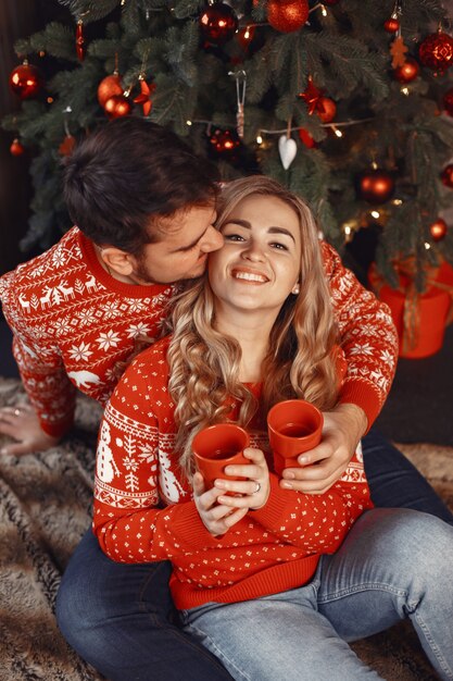 Pessoas em uma decoração de Natal. Homem e mulher com uma camisola vermelha.