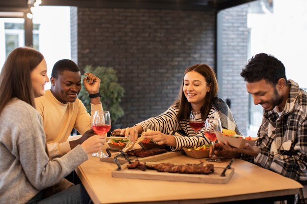 Pessoas em uma reunião comendo e bebendo vinho