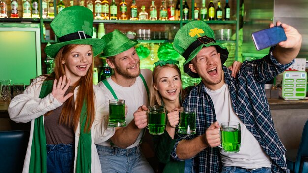 Pessoas felizes celebrando st. patrick's day e tirando selfie