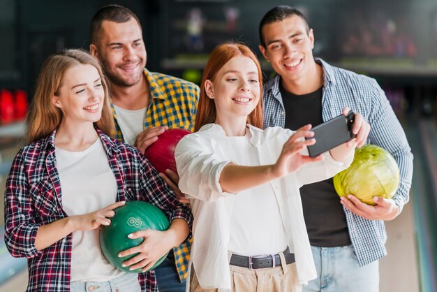 Pessoas felizes posando em um clube de boliche