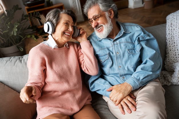 Pessoas idosas com fones de ouvido de alto ângulo