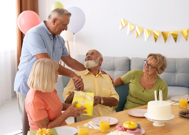 Pessoas idosas em cena média comemorando aniversário