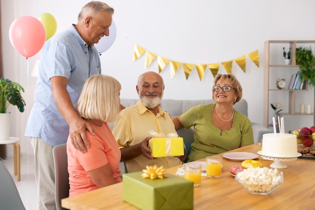 Pessoas idosas em cena média comemorando aniversário