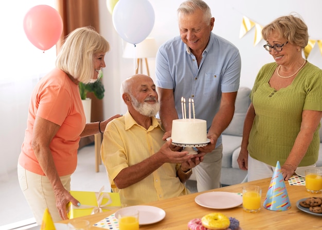 Pessoas idosas em cena média comemorando aniversário