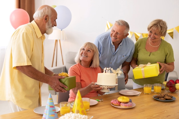 Pessoas idosas em cena média comemorando aniversário