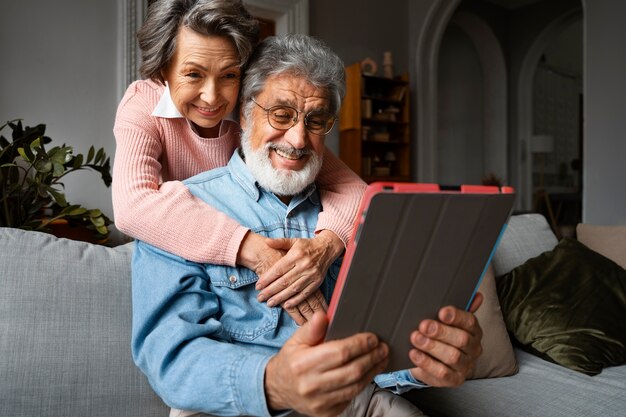 Pessoas idosas sorridentes com tablet de baixo ângulo