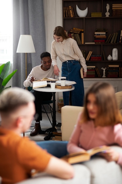 Foto grátis pessoas na biblioteca lendo livros