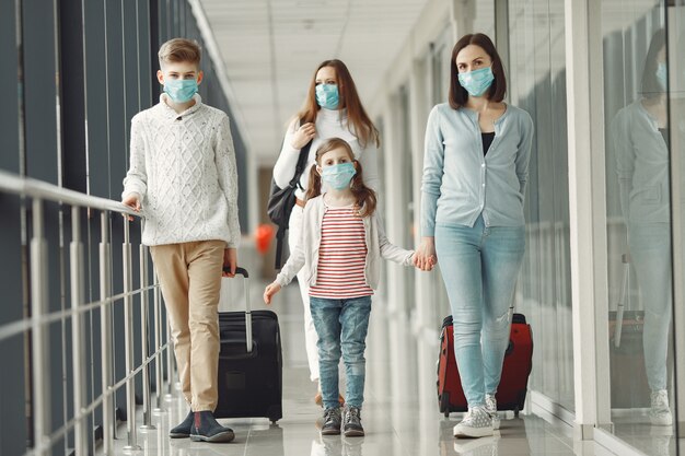 Pessoas no aeroporto estão usando máscaras para se protegerem de vírus