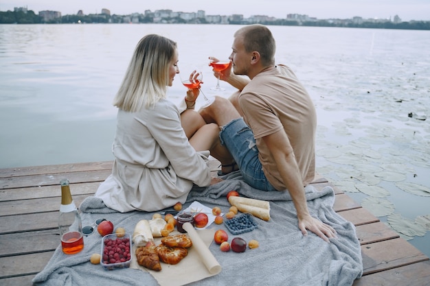 Foto grátis pessoas perto do rio. piquenique delicioso de verão saudável na grama. frutas em uma blancet.