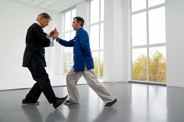 Foto grátis pessoas praticando tai chi tiro completo