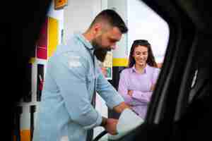 Foto grátis pessoas que passam o tempo no posto de gasolina