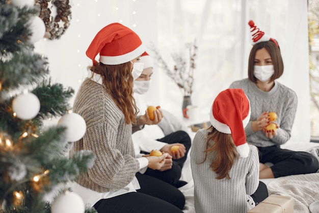 Pessoas reparando pelo Natal. Duas mães brincando com seus filhos. Coronavirus thime. Isolamento.