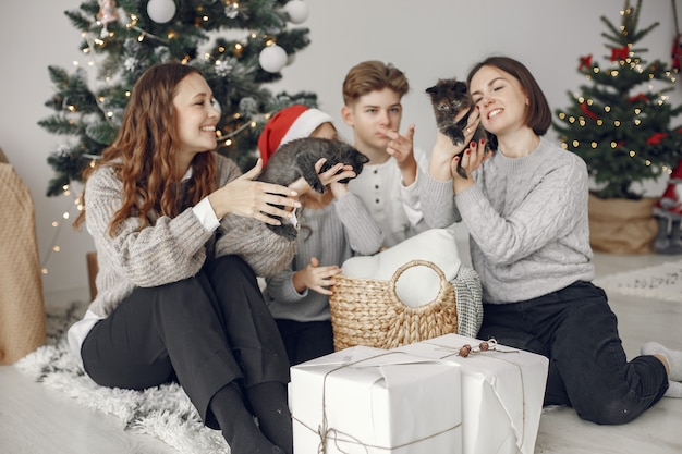 Pessoas reparando pelo Natal. Pessoas sentadas perto da árvore de Natal.