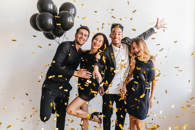 Foto grátis pessoas se divertindo na festa com balões pretos e confetes