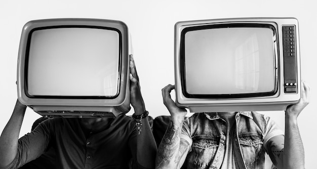 Foto grátis pessoas segurando televisão retrô ao lado do outro