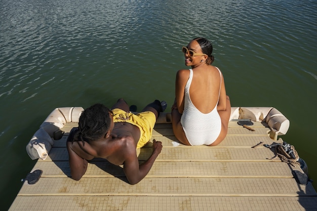 Foto grátis pessoas sentadas à beira do lago de alto ângulo