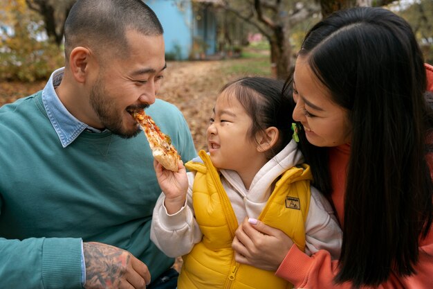 Pessoas sorridentes comendo pizza vista frontal