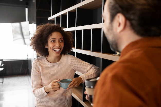 Foto grátis pessoas sorridentes conversando no trabalho durante o intervalo