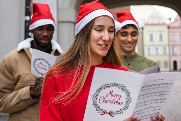 Pessoas sorridentes de tiro médio cantando canções de natal