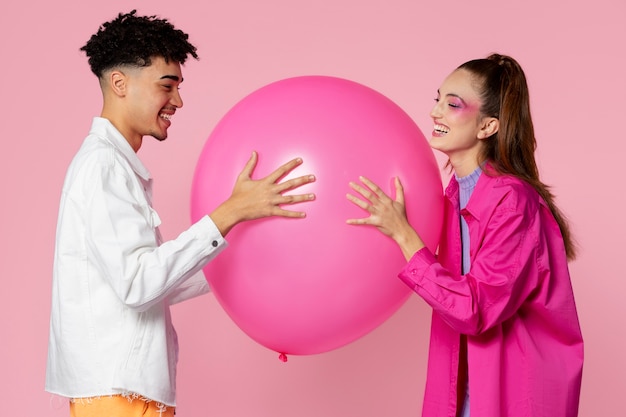 Pessoas sorridentes de tiro médio com balão rosa