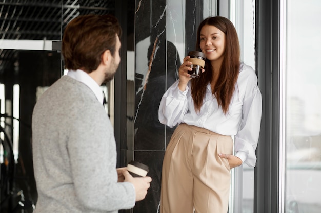 Pessoas sorridentes de tiro médio conversando no trabalho