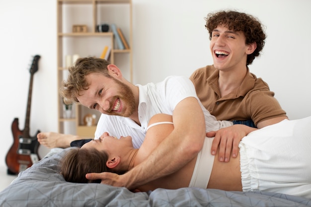 Pessoas sorridentes de tiro médio deitadas na cama